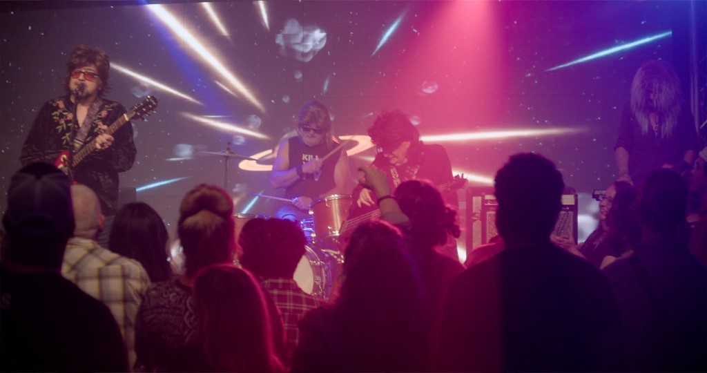 The band performing live on stage with a cosmic backdrop