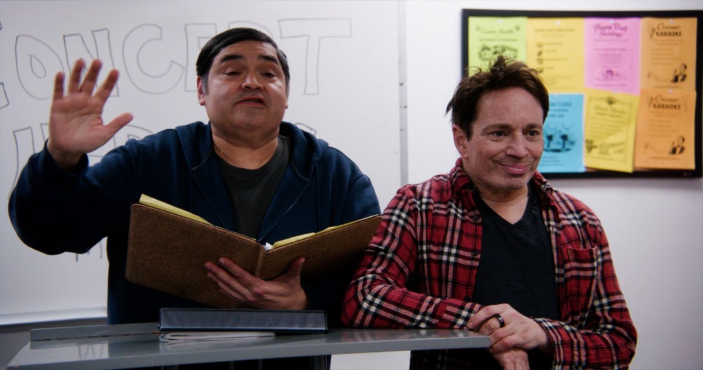 The two main characters of Concert Heroes at a desk with CONCERT written on the whiteboard